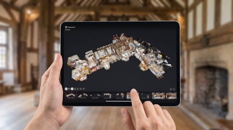 Museum curator using a tablet to review a 3D virtual tour funded by an Arts Council grant