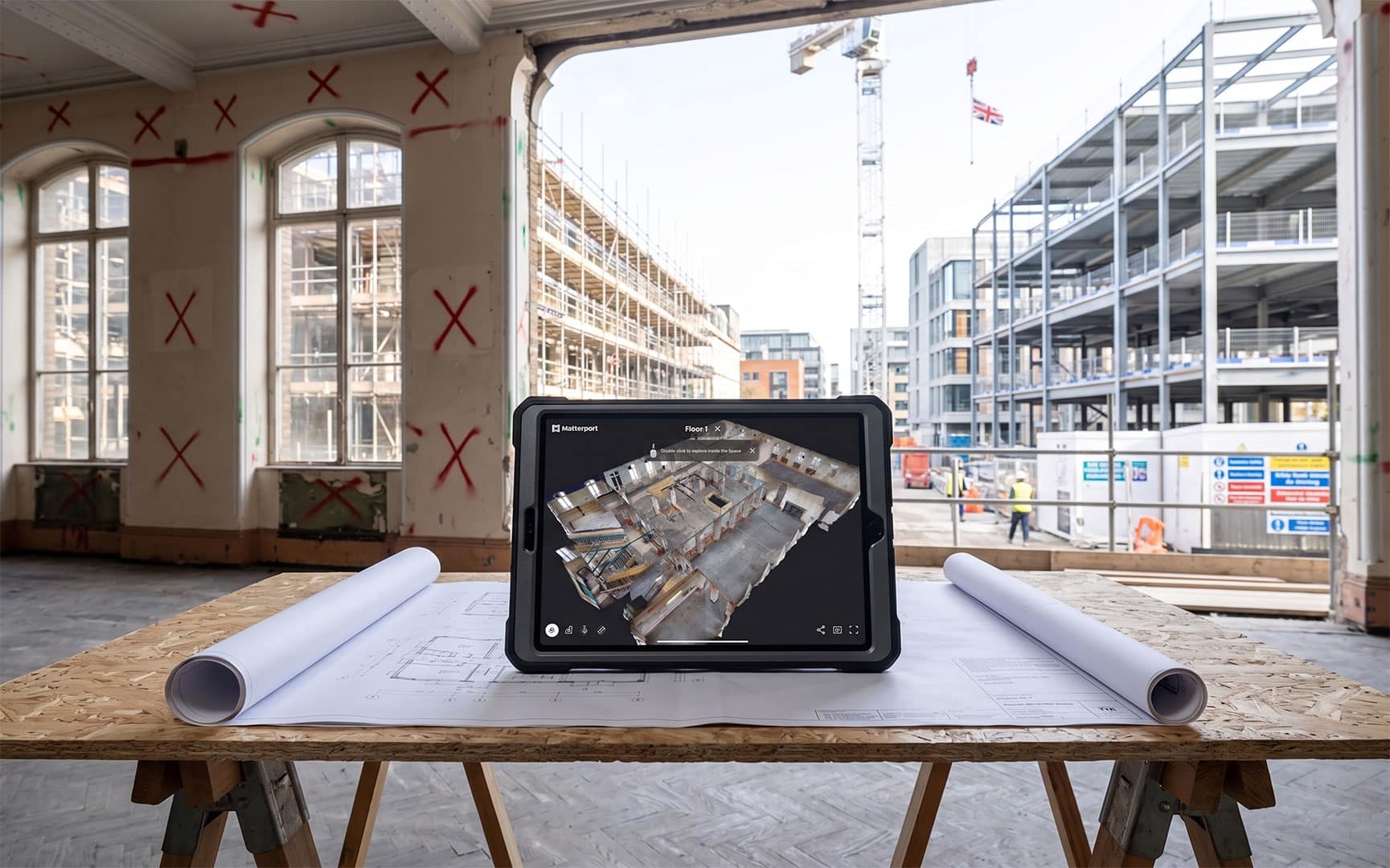 A rugged iPad on a UK construction site displaying a highly accurate 3D point cloud scan, representing enterprise construction virtual tours and BIM data capture.