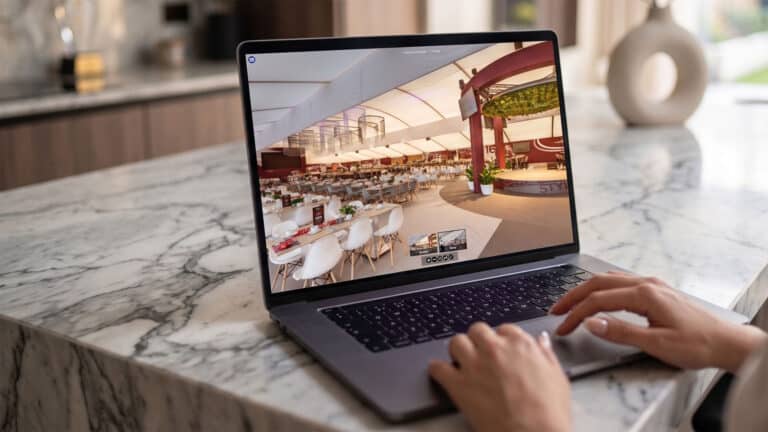 Hospitality event planner reviewing a 3D hotel virtual tour on a laptop