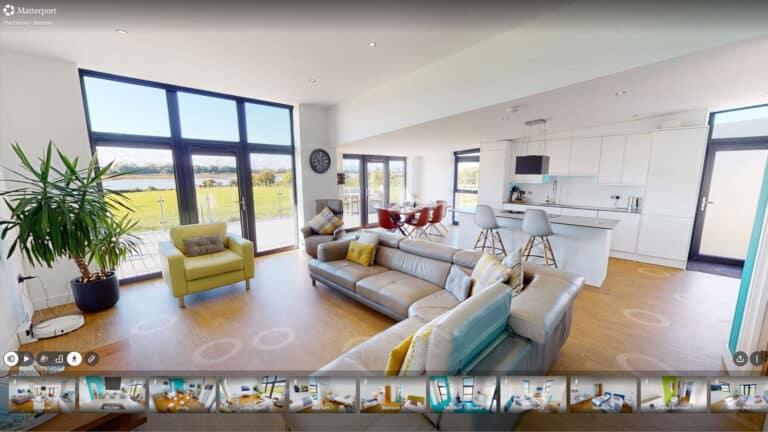 A smartphone displaying a 360 virtual tour of a luxury serviced apartment with a direct booking button on the screen.